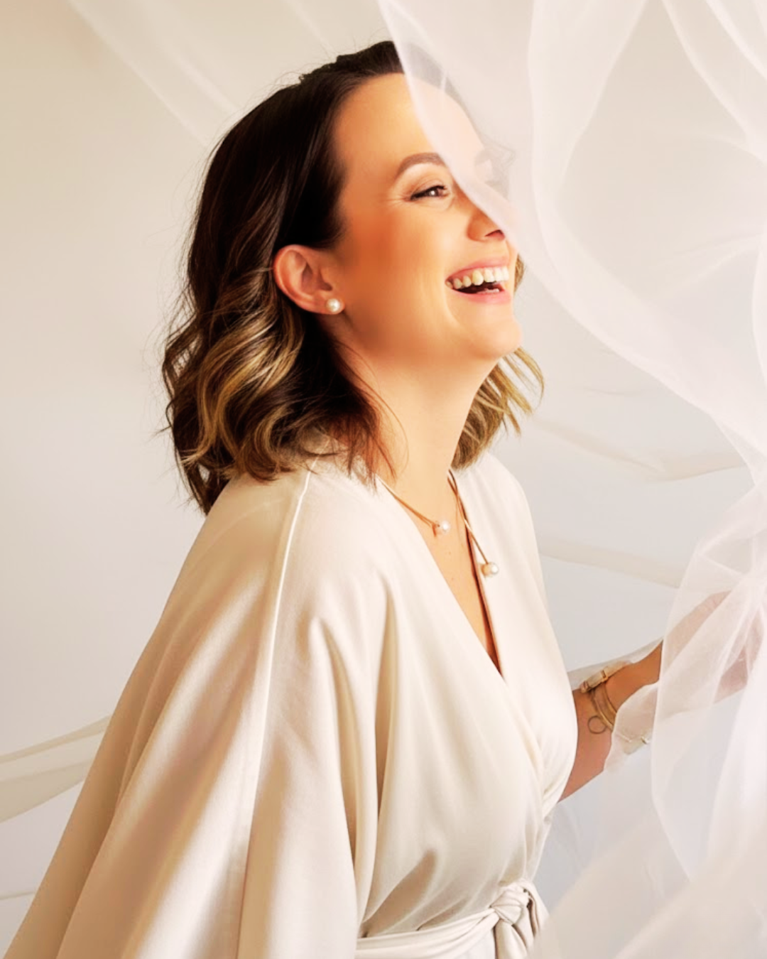 Li Cioldin sorrindo, envolta em véu translúcido